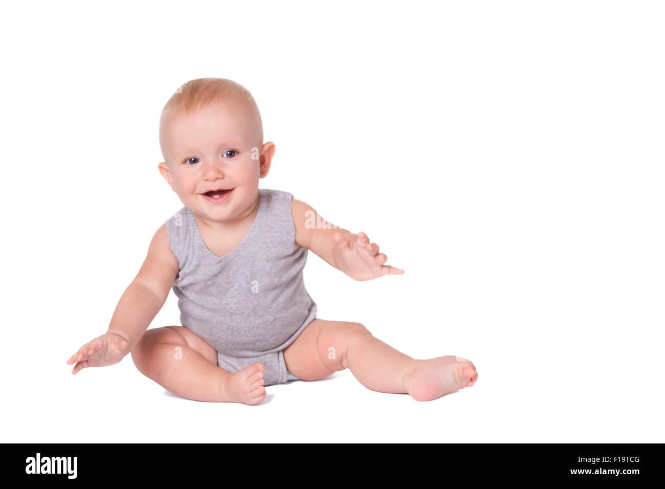 Studio shot of baby boy jouant sur le sol à la recherche de l'appareil photo. Banque D'Images