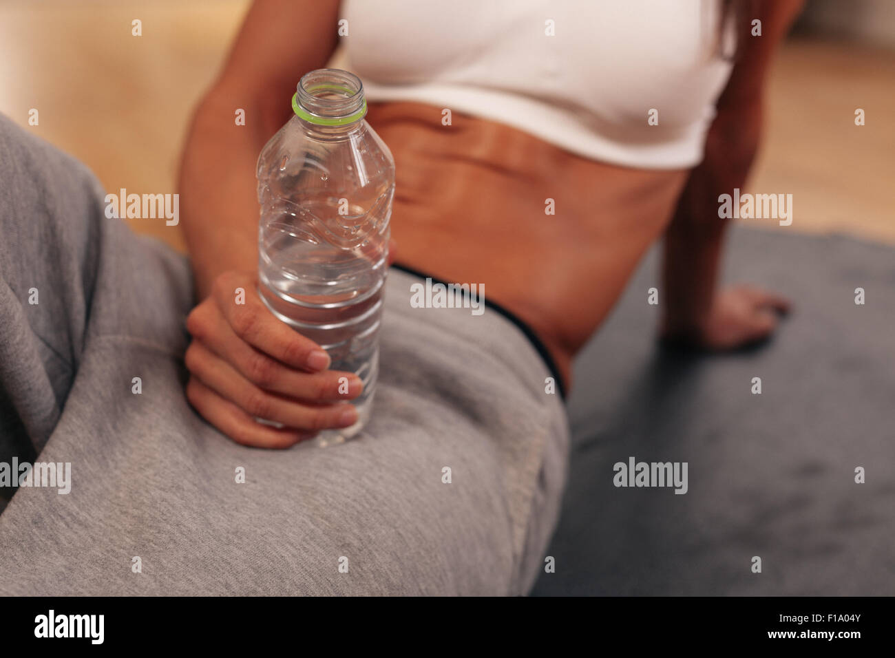 Close-up portrait of woman holding remise en forme bouteille d'eau à la salle de sport. Faire une pause après la formation. Banque D'Images
