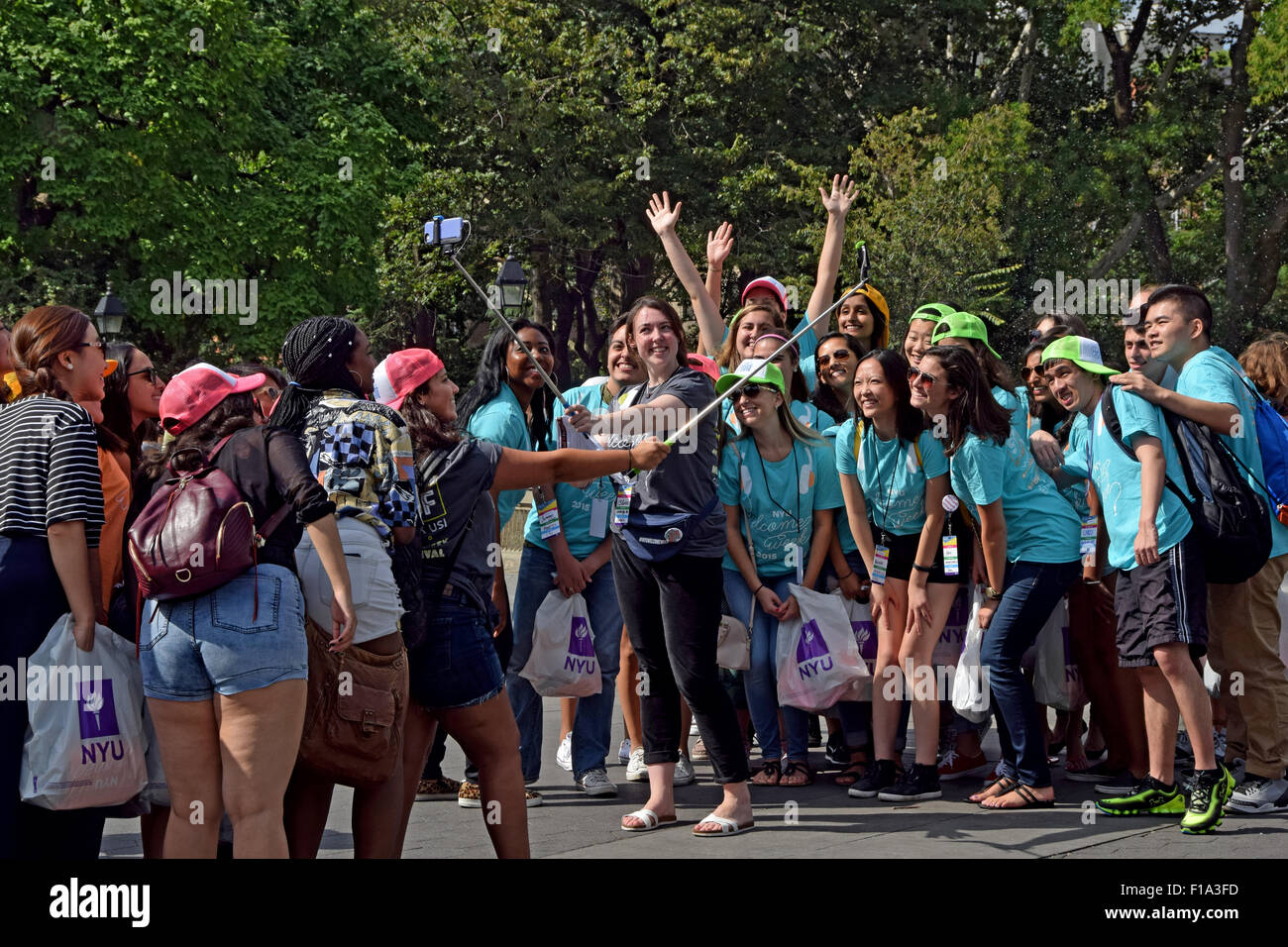 Les élèves et étudiants de la NYU NYU greeters pour les nouveaux étudiants posent pour une en selfies Washington Square Park à New York City Banque D'Images