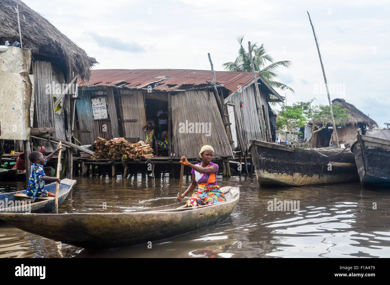 Dame sur une pirogue Ganvié, la "Venise de l'Afrique", village de maisons sur pilotis sur un lac près de Cotonou au Bénin Banque D'Images