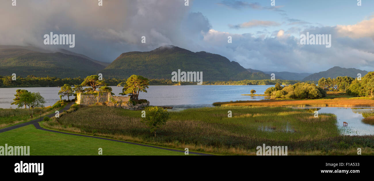 Aube sur McCarthy Mor château le long de Lough Leane, le Parc National de Killarney, comté de Kerry, Irlande Banque D'Images