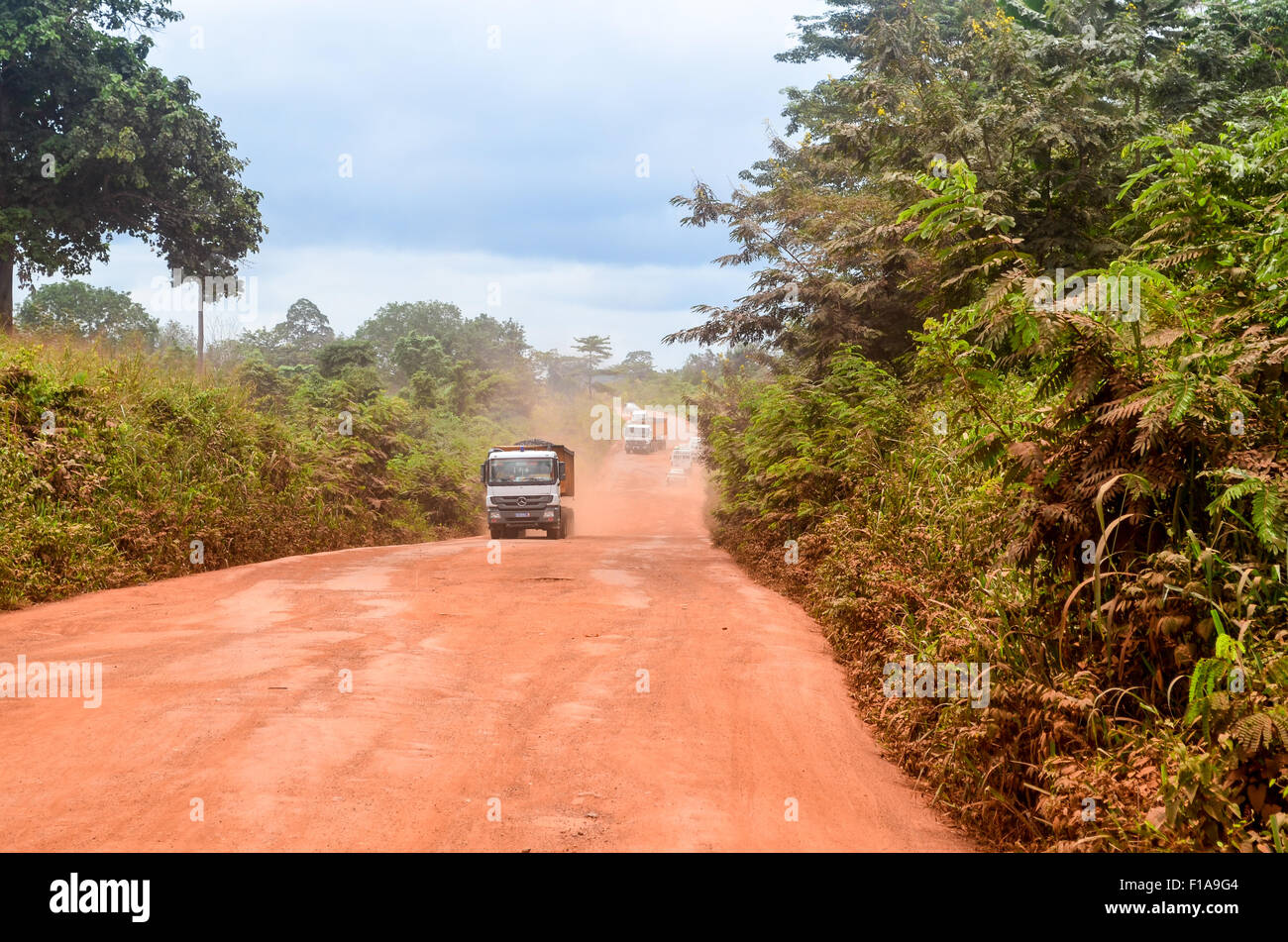 Les camions sur une route de terre rouge terre en milieu rural en Afrique Banque D'Images