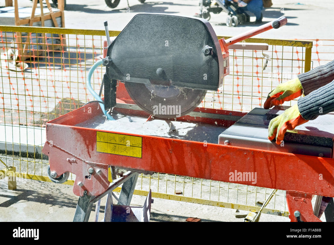 Travailleur manuel qui coupe le béton pour paver la rue Banque D'Images