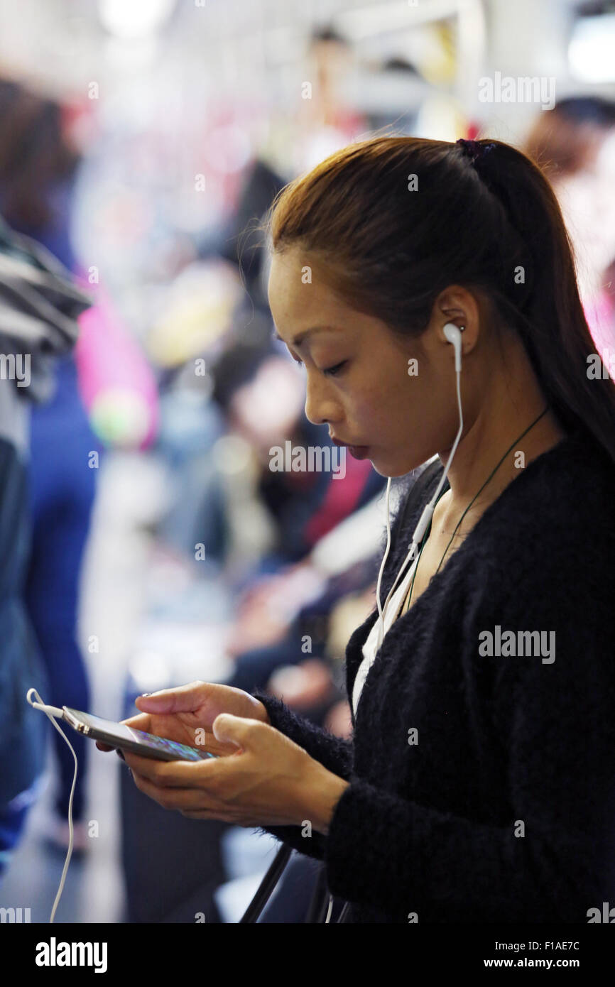 Hong Kong, Chine, femme d'écouter de la musique avec votre smartphone Banque D'Images