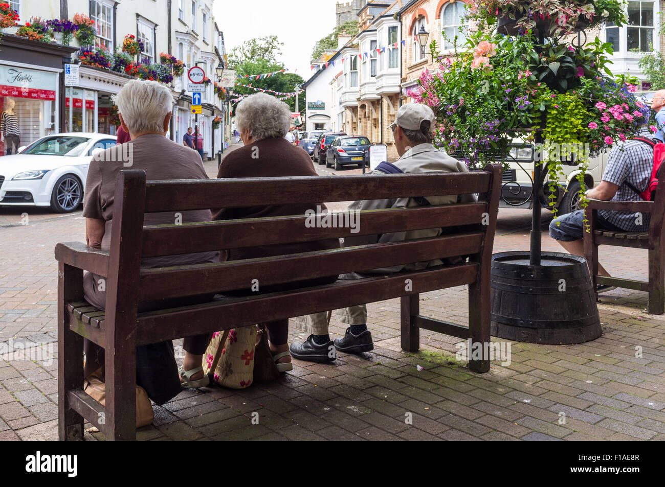 La ville de Sidmouth, Devon. 2015. Un groupe de trois retraités sont assis sur un banc public dans le centre-ville de Cornwall. Banque D'Images
