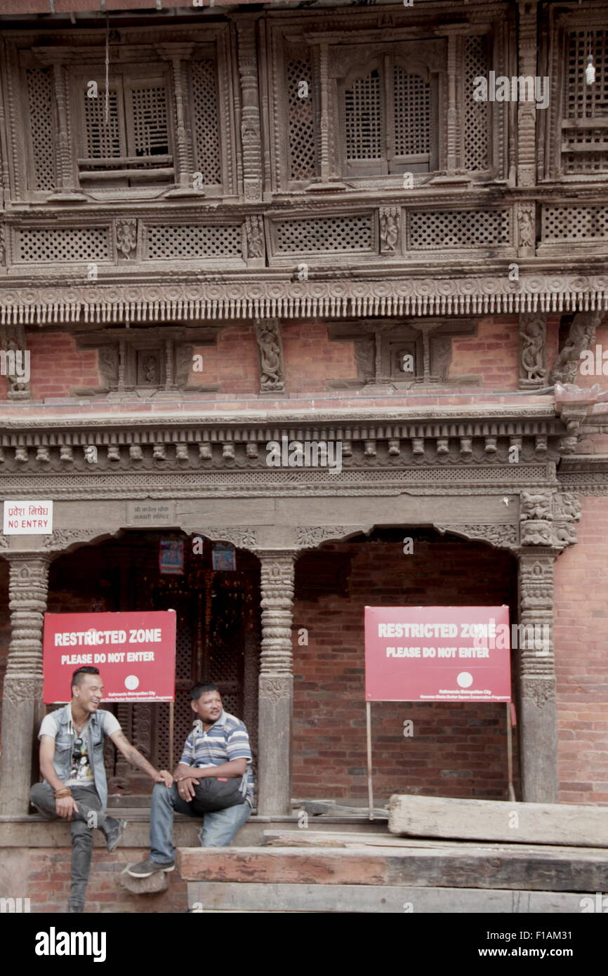 Deux hommes se détendre dans Durbar Square après le tremblement de terre de 2015 avril à Katmandou Banque D'Images