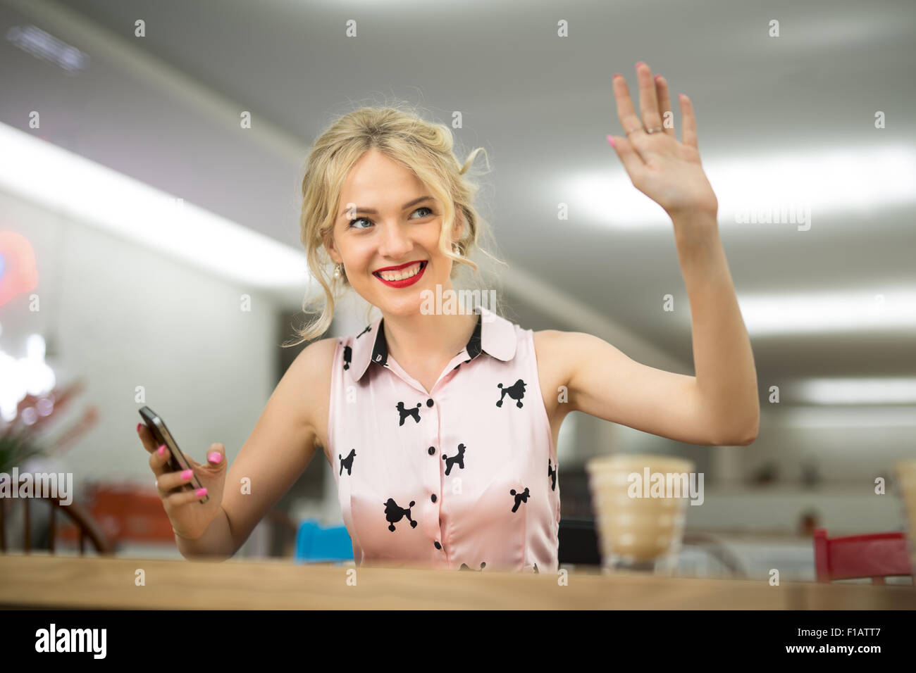 Cute blonde gesturing part quelqu'un Banque D'Images