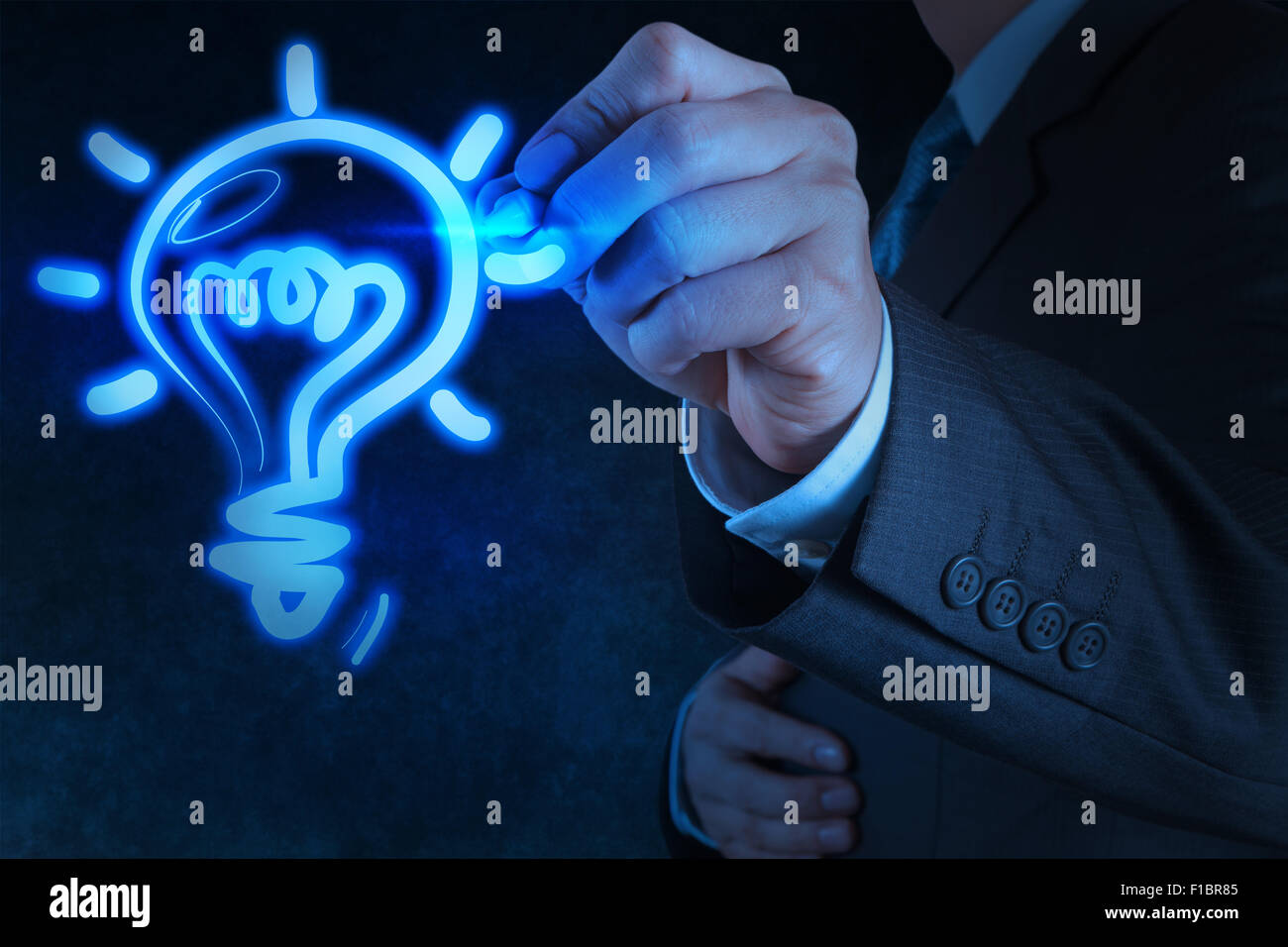 Businessman la main avec un stylo ampoule dessin sur écran tactile Banque D'Images