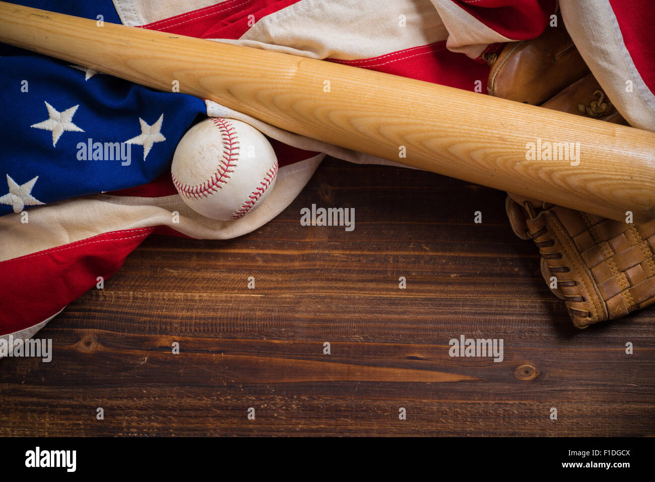 Un vieux, antique vintage drapeau américain avec l'équipement de base-ball sur un banc en bois Banque D'Images