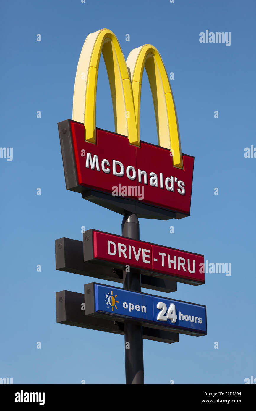 Conduire à travers Mc Donald's sign contre un ciel bleu profond. A ouvert 24 signe sous le logo M classique et Drive-Thru signe. Banque D'Images
