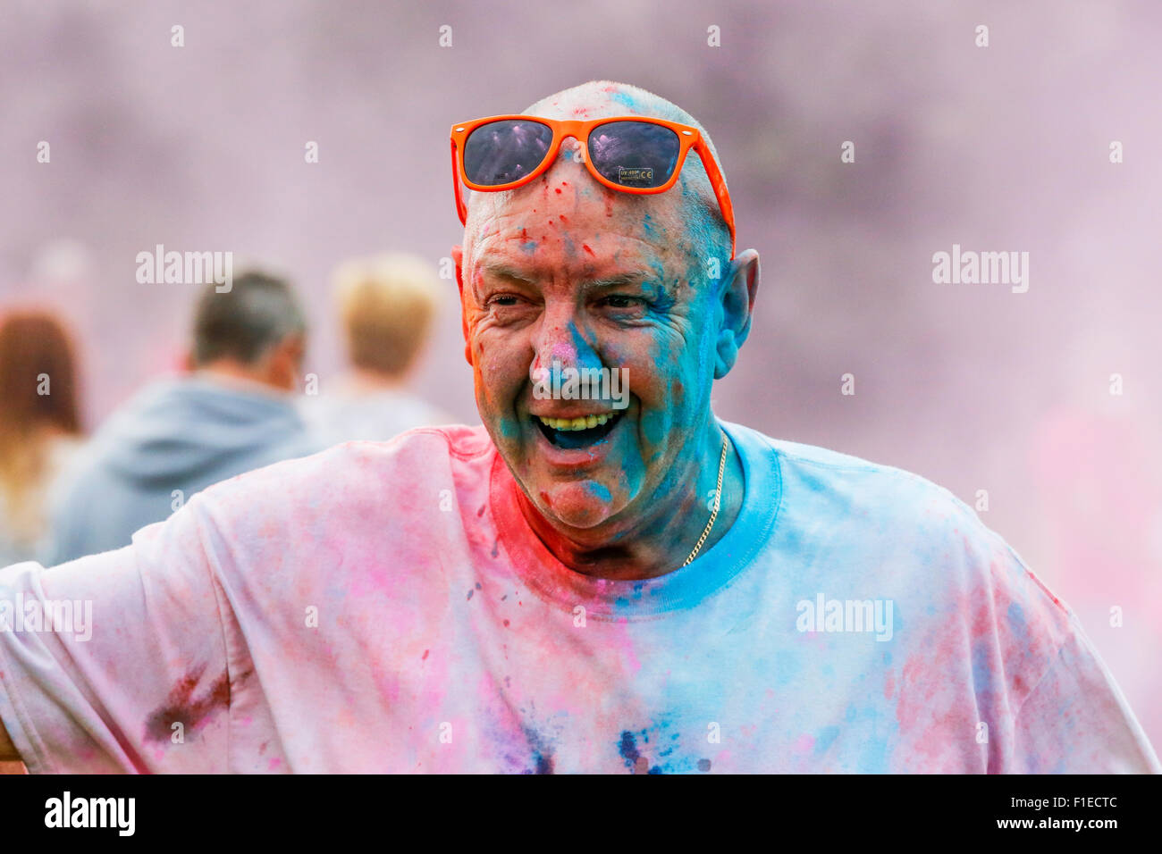 L'homme couvert de poudres multicolores et la peinture lorsqu'il a pris part à une course de bienfaisance de bord Couleur,Kilwinning, Ayrshire, Scotland Banque D'Images