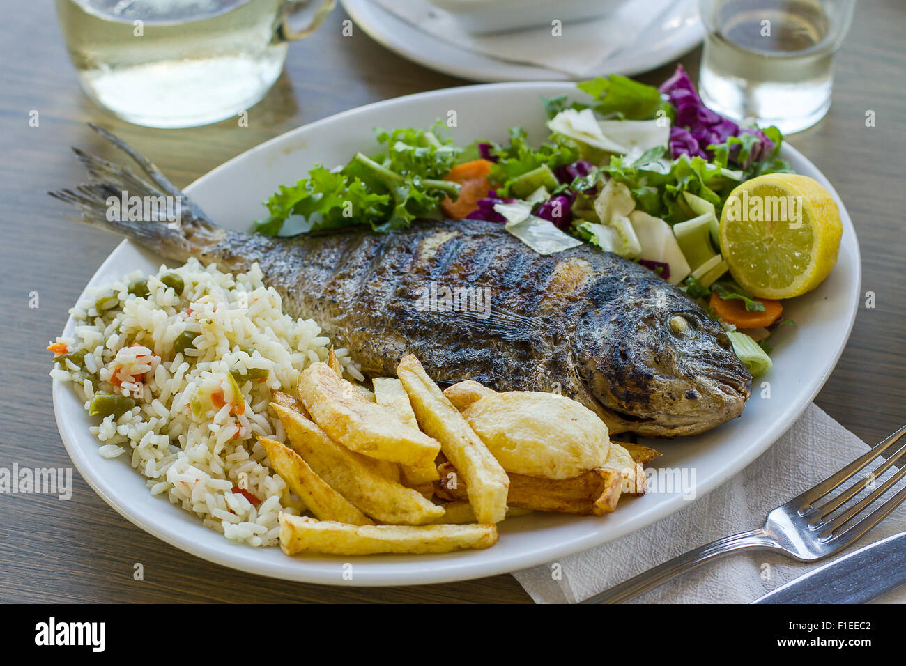 Dorade avec pomme de terre, riz et salade, la nourriture grecque Banque D'Images