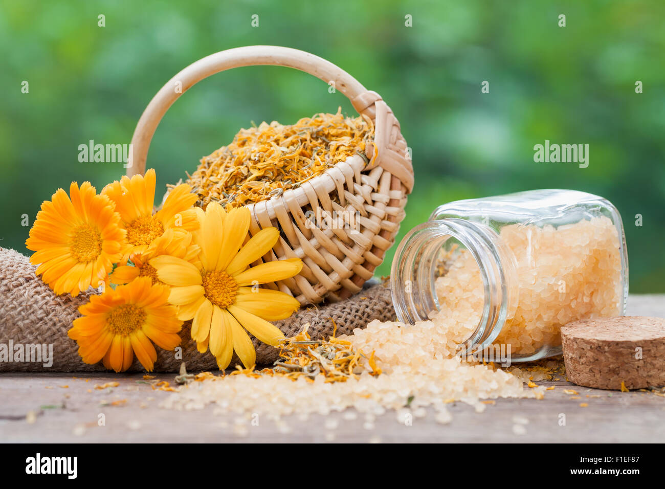 Marigold fleurs, panier de plantes séchées et de bouteilles de sel de mer. Banque D'Images