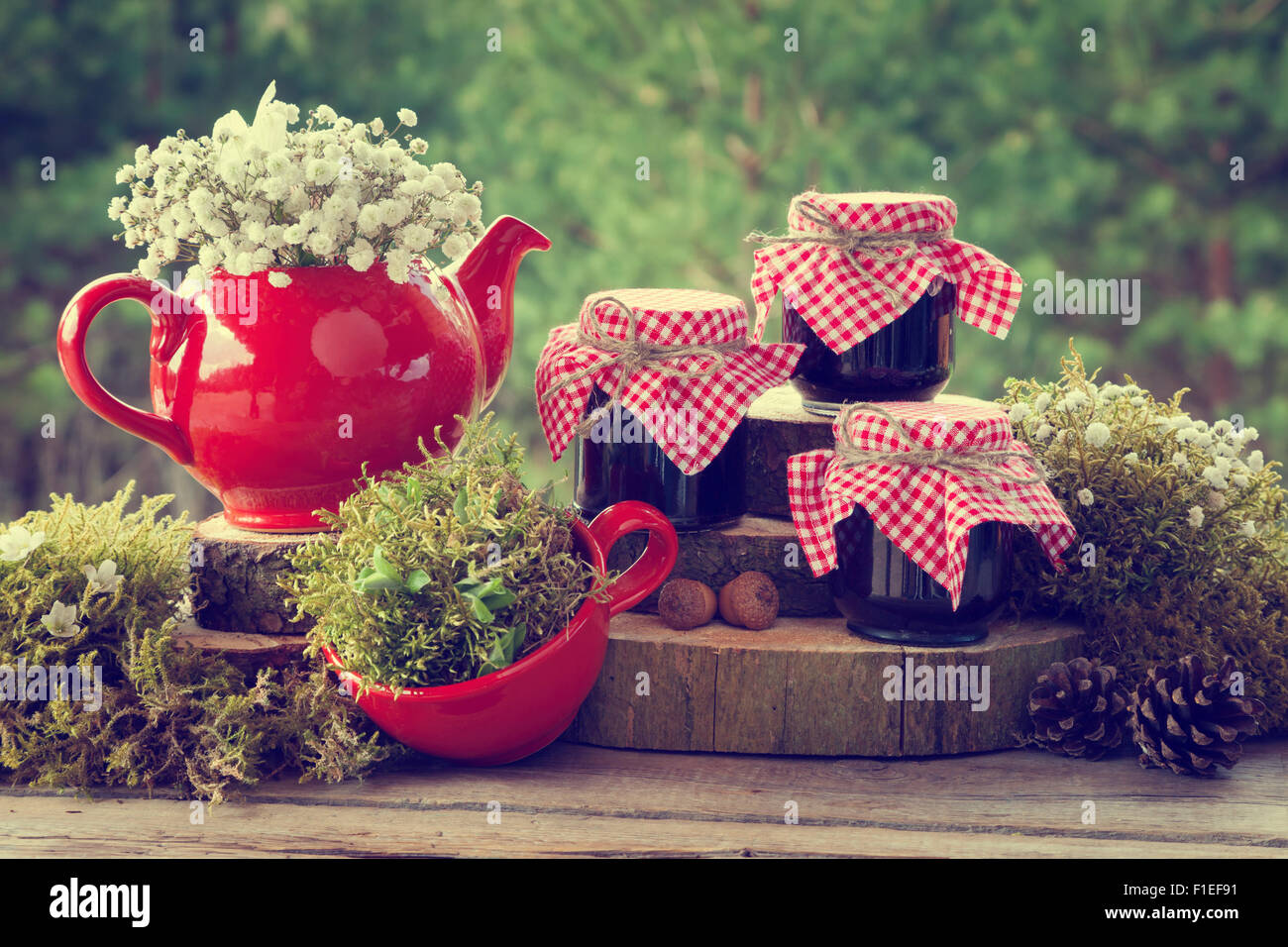 Red Teapot, tasse de thé et petits pots de confiture en bonne santé. Décorations de mariage dans un style rustique. Banque D'Images