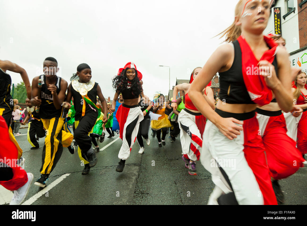 Leeds, UK. Août 31, 2015. Le RJC membres danse courir pour rattraper le reste du défilé après avoir dansé le long de Roundhay Road pendant le défilé de carnaval Antillais de Leeds, West Yorkshire, UK Crédit : Graham Hardy/Alamy Live News Banque D'Images
