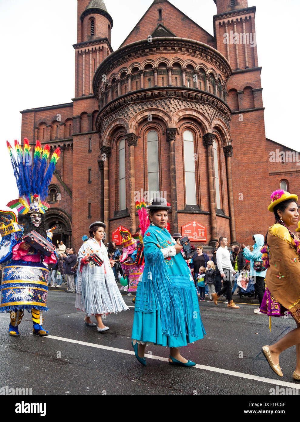 Leeds, UK. Août 31, 2015. Une femme vêtue d'un costume traditionnel carnaval bolivien, tenant un hochet bus, promenades en face de l'église St Aidans Roundhay sur route au cours de la Leeds West Indian Carnival Parade, West Yorkshire, UK Crédit : Graham Hardy/Alamy Live News Banque D'Images