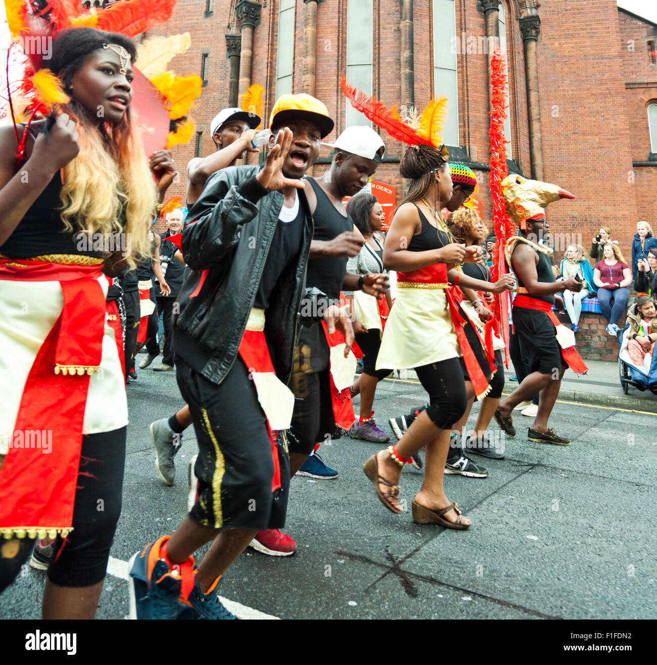 Leeds, UK. Août 31, 2015. Le carnaval des jeunes Solidarité Dynamix Leeds crew habillé en rouge et noir curiepe dance le long de Roundhay Road pendant le défilé de carnaval Antillais de Leeds, West Yorkshire, UK Crédit : Graham Hardy/Alamy Live News Banque D'Images