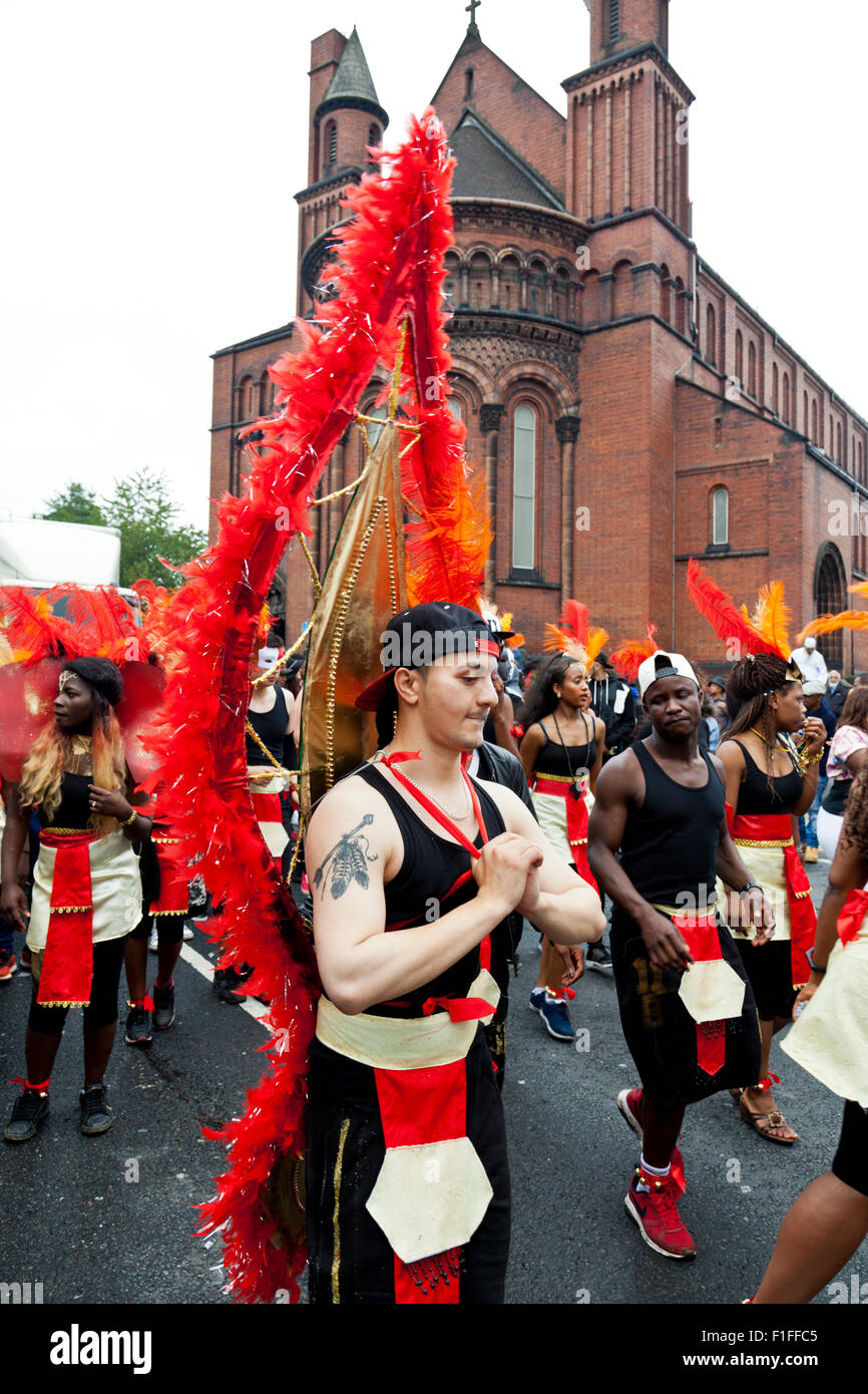 Leeds, UK. Août 31, 2015. Le carnaval des jeunes Solidarité Dynamix Leeds crew habillé en rouge et noir le long de la danse costumes Roundhay Road pendant le défilé de carnaval Antillais de Leeds, West Yorkshire, UK Crédit : Graham Hardy/Alamy Live News Banque D'Images