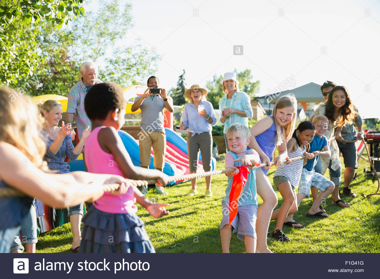 Encourager les enfants jouaient voisins Tug-of-war park Banque D'Images