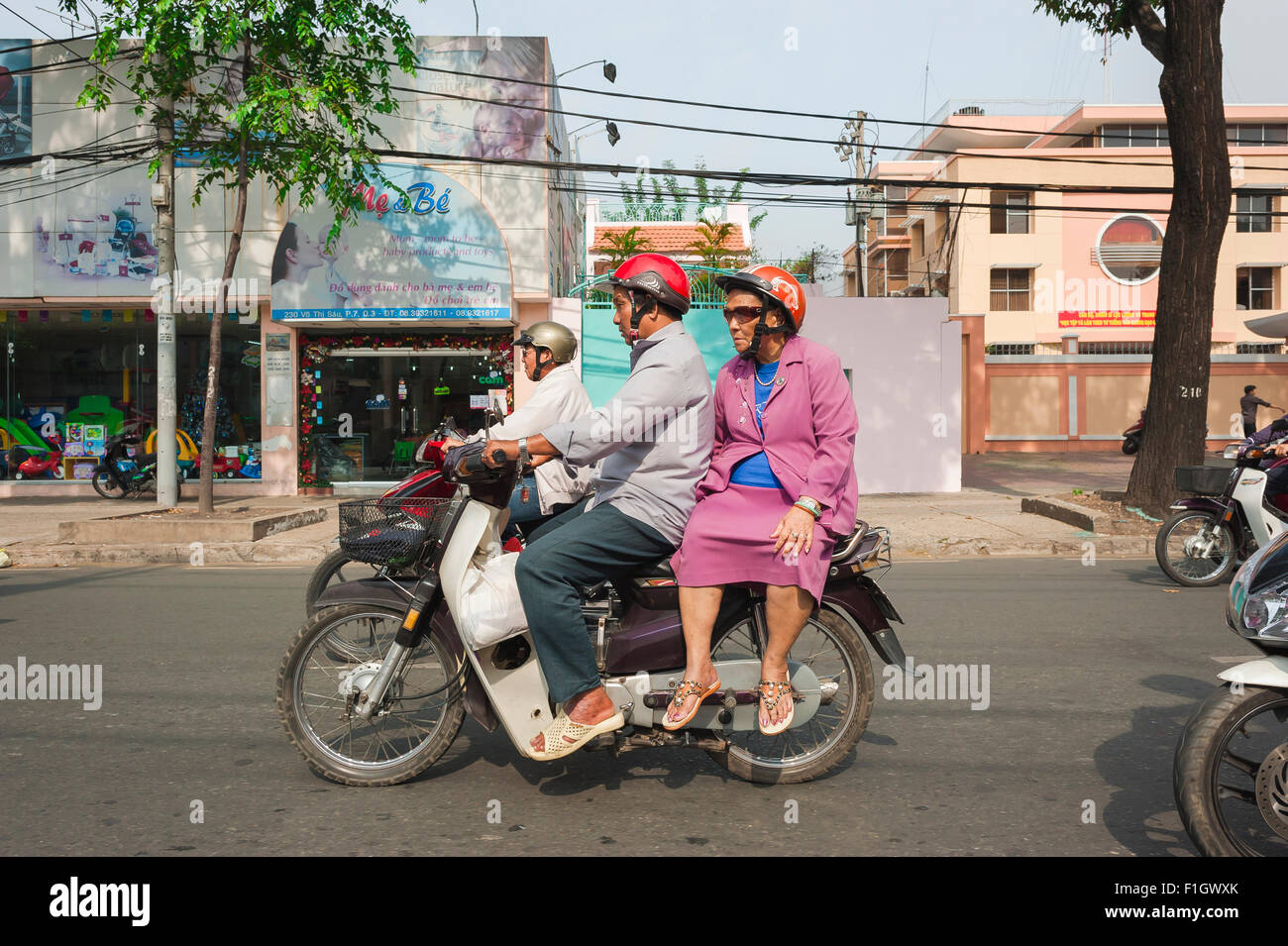 Les personnes âgées moto, un couple de personnes âgées vitesse par le trafic d'heures de pointe sur une moto à Tran Hung Dao à Ho Chi Minh Ville, Saigon, Vietnam Banque D'Images