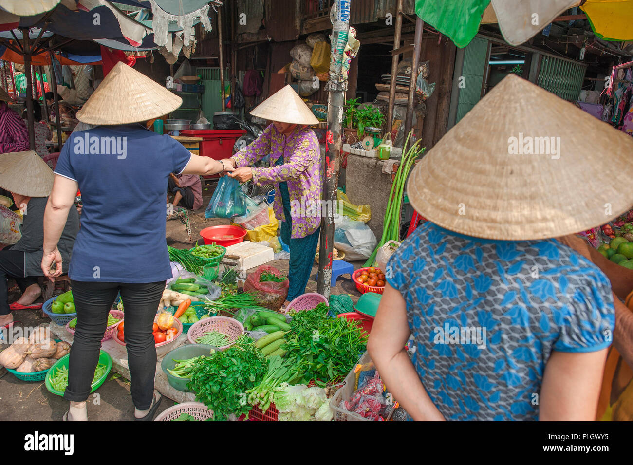 Vietnam shopping femme, une femme boutiques pour les légumes sur un trottoir en décrochage, Cholon, le marché Binh Tay, Ho Chi Minh Ville, Saigon, Hanoi, Vietnam. Banque D'Images