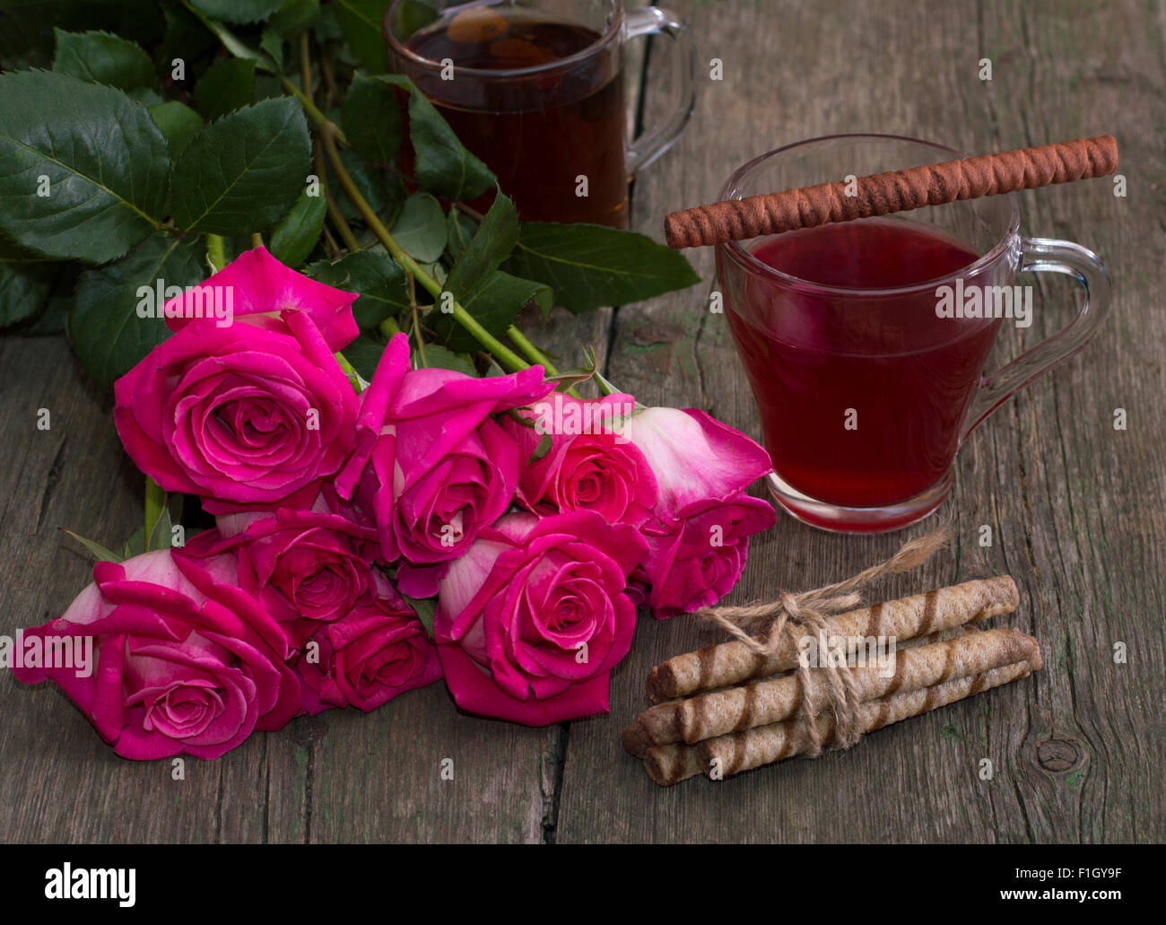 Roses rouges et deux verres de thé Banque D'Images