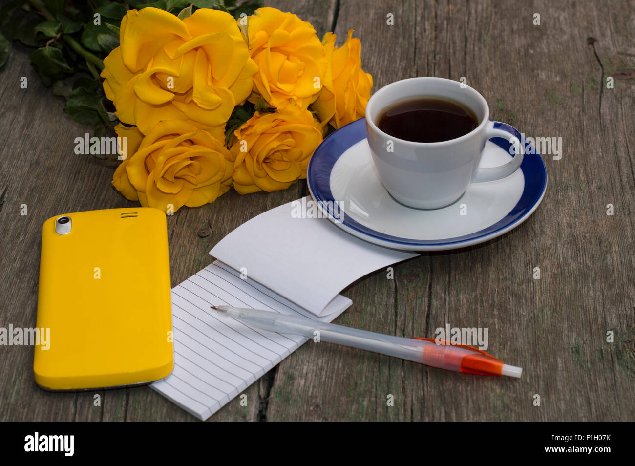 Des roses jaunes, ordinateur portable, café et téléphone jaune Banque D'Images