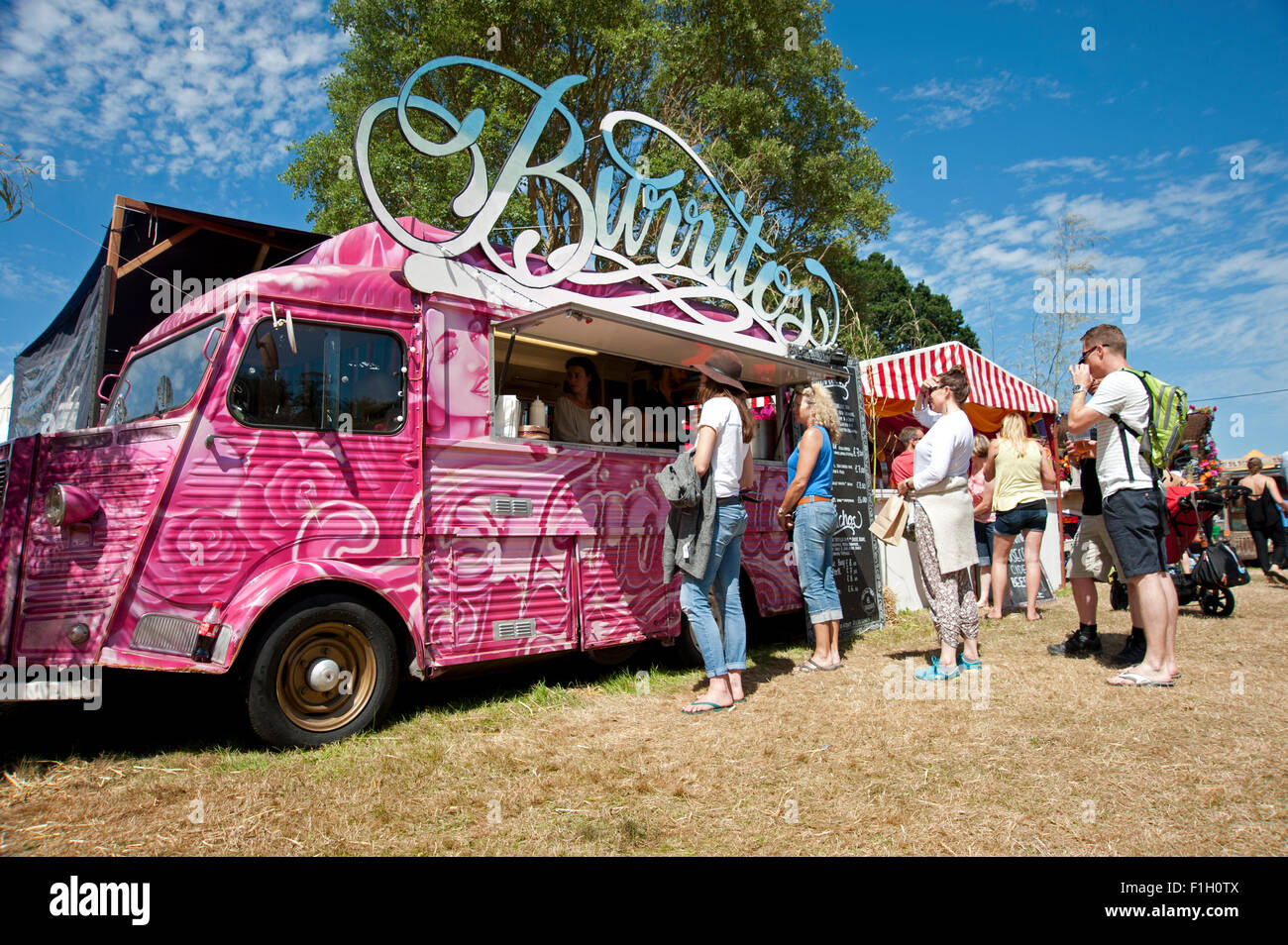 Festivaliers file d'attente pour les burritos à une cuisine mobile dans le soleil de l'été au Port Eliot Cornwall Festival Banque D'Images