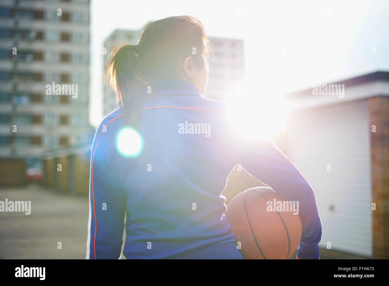 Vue arrière du joueur de basket-ball féminin mature holding ball Banque D'Images