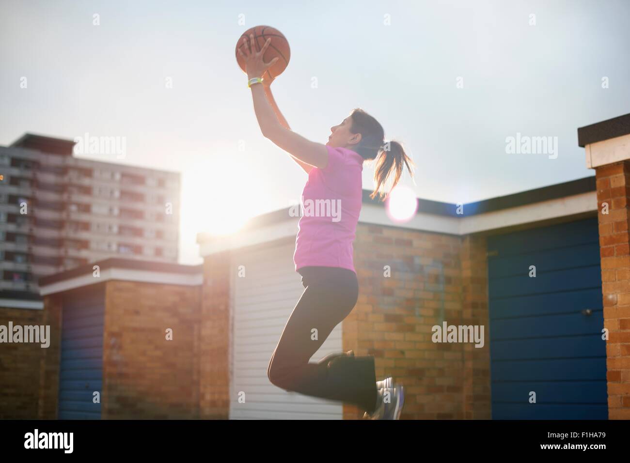 Femelle adulte basket-ball catching ball mid air Banque D'Images