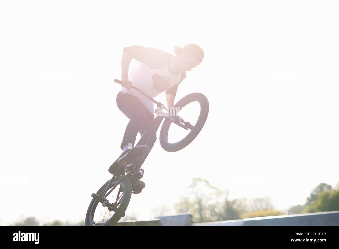 Jeune homme faisant stunt bmx sur at skatepark Banque D'Images