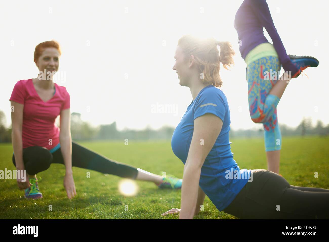 Trois femmes de l'exercice et s'étend dans le parc Banque D'Images