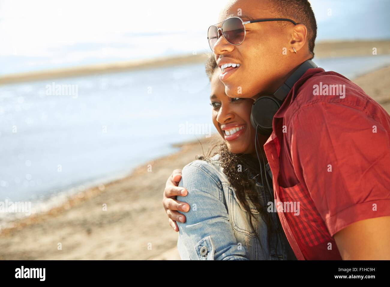 Young woman smiling on beach, serrant à la voiture Banque D'Images