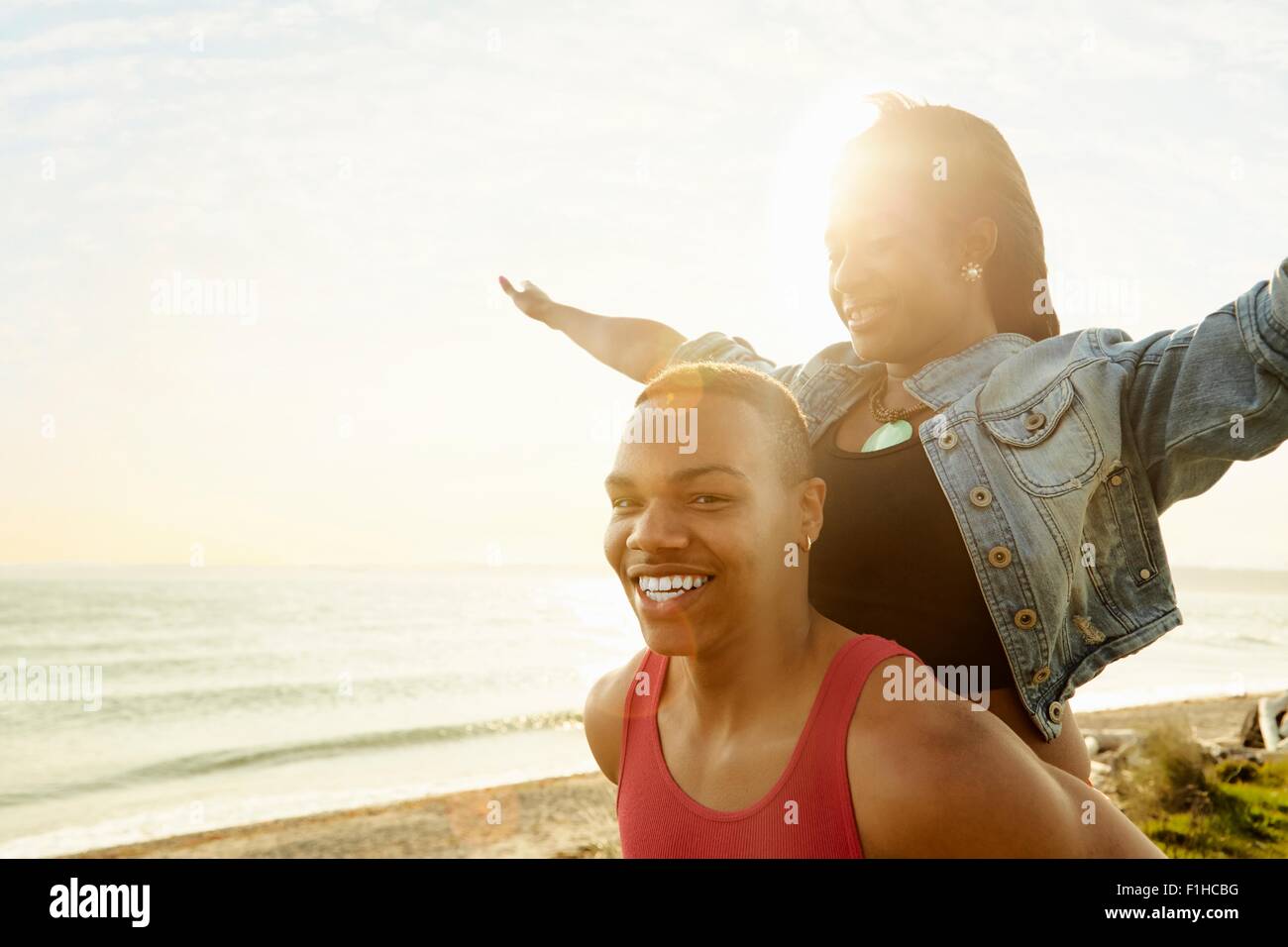Young woman standing behind man, looking at camera Banque D'Images