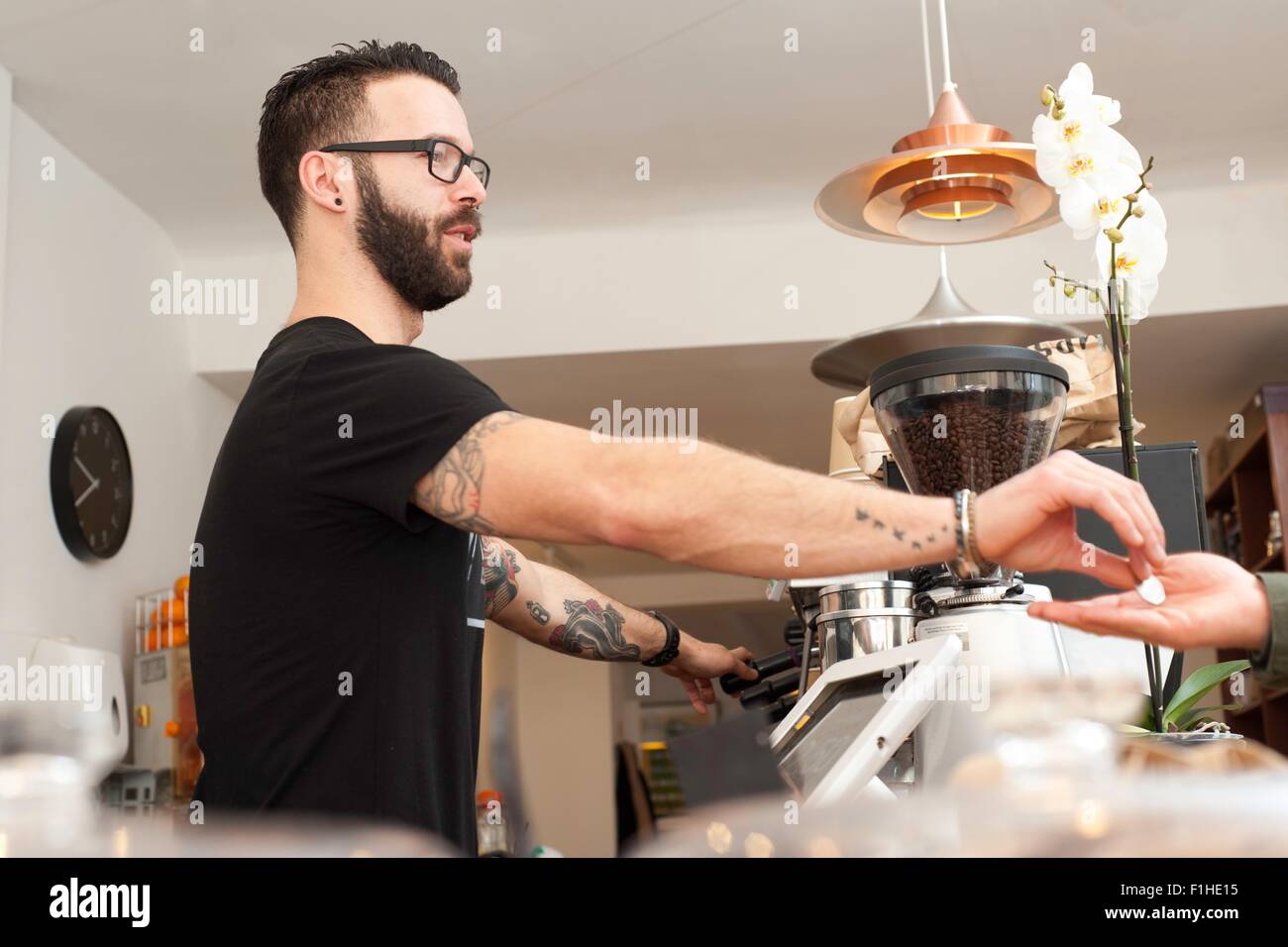 Cafe waiter remise au client des pièces à partir de présentoirs de comptoir Banque D'Images