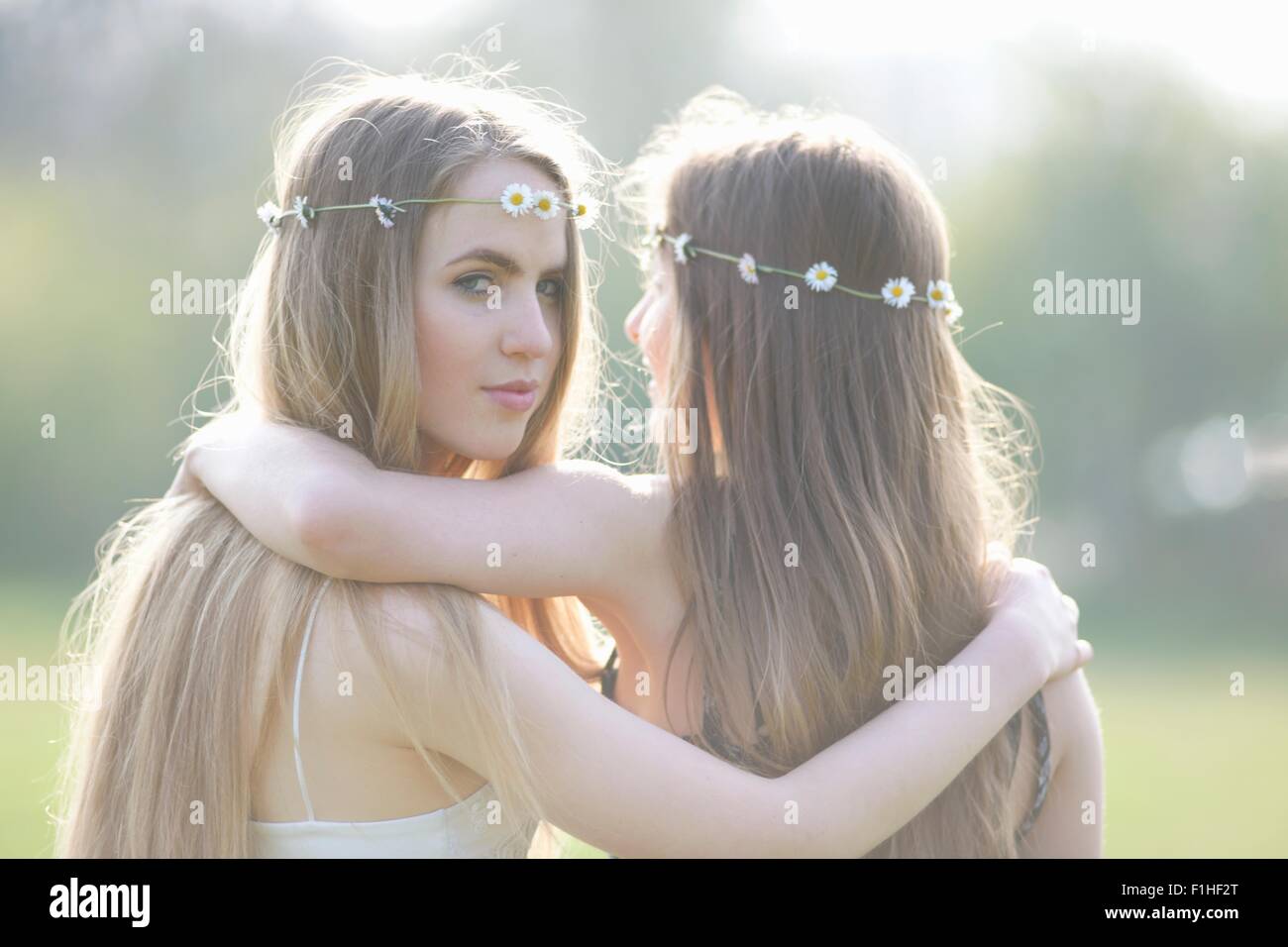 Portrait de deux adolescentes portant des coiffes en guirlande dans park Banque D'Images