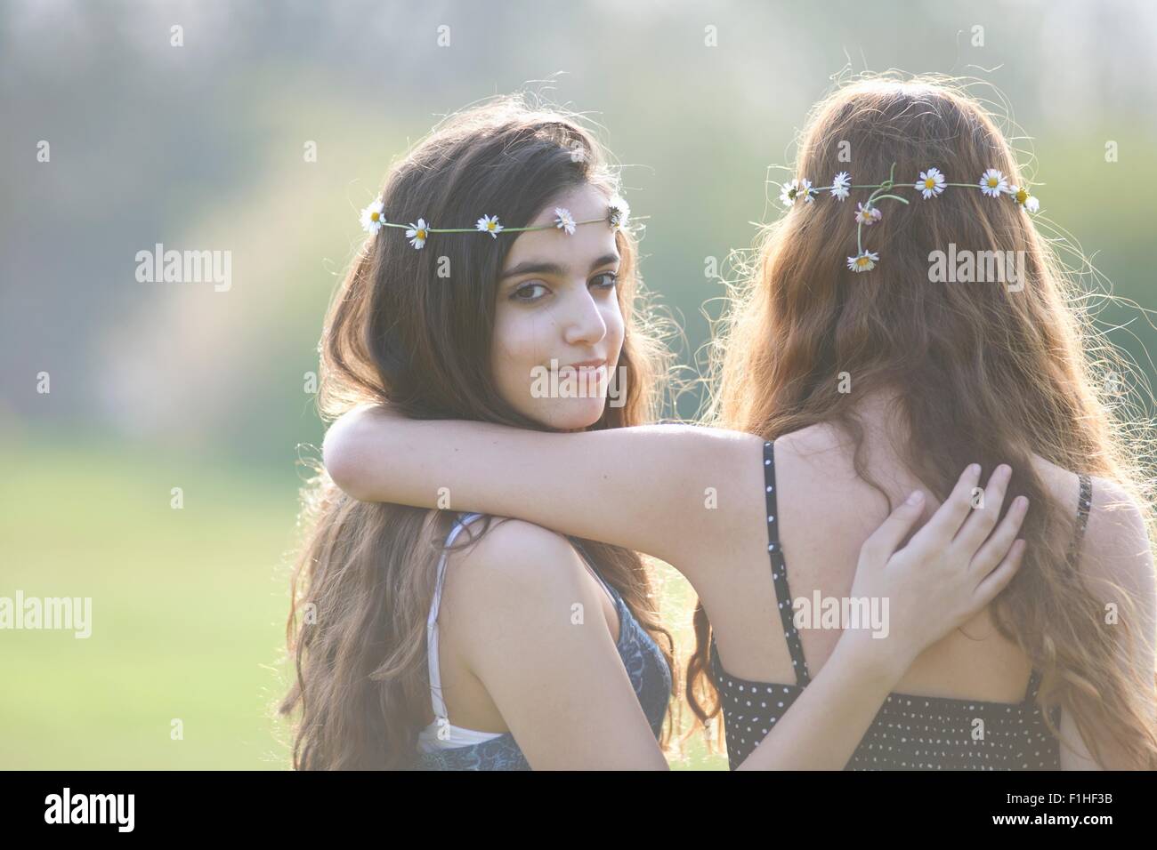 Vue arrière portrait de deux adolescentes portant des coiffes en guirlande dans park Banque D'Images