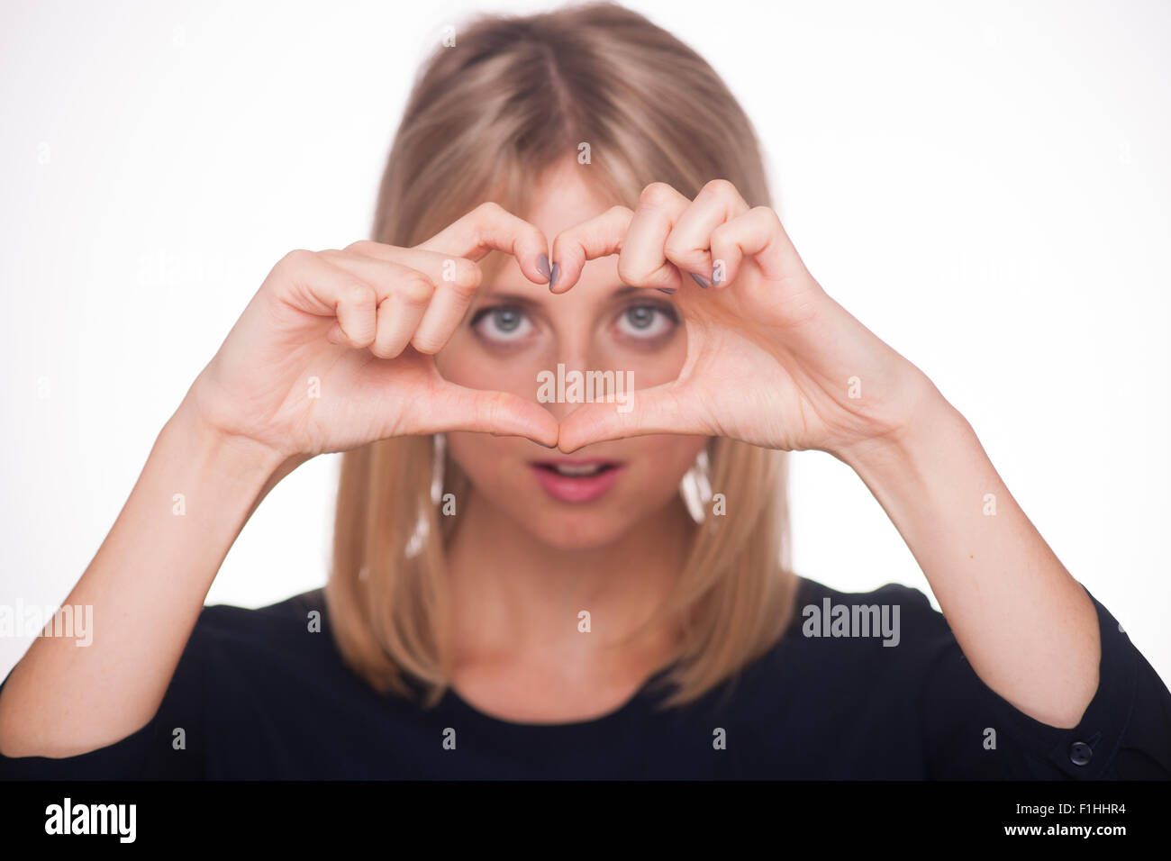 Femme blonde faire un cœur avec ses mains Banque D'Images