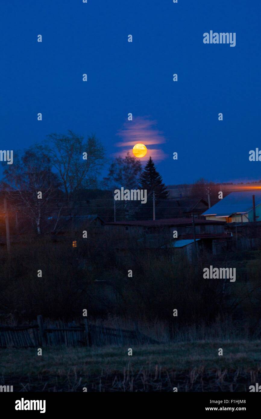 Scène rurale avec lune qui brille au-dessus des arbres, Sarsy village, région de Sverdlovsk, Russie Banque D'Images