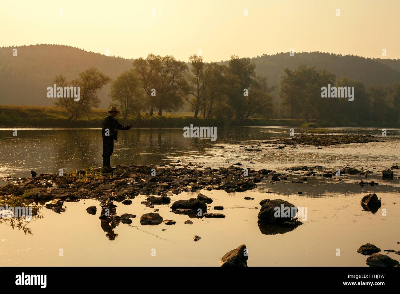 Mid adult man la pêche dans le lac, Sarsy village, région de Sverdlovsk, Russie Banque D'Images