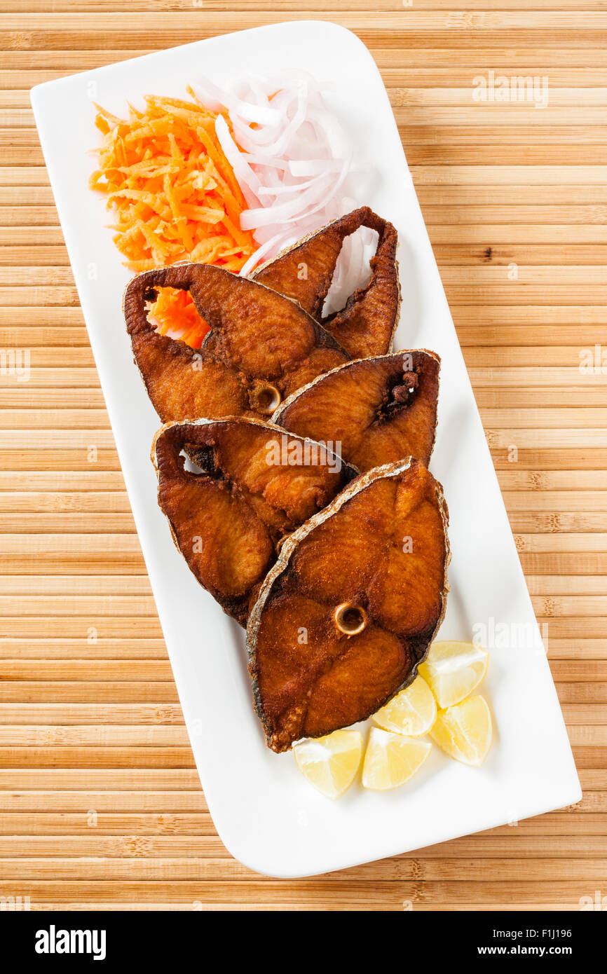 Vue de dessus de délicieux filets de poisson maquereau seer/fry servi avec des carottes râpées, des matières d'oignon, citron. Banque D'Images