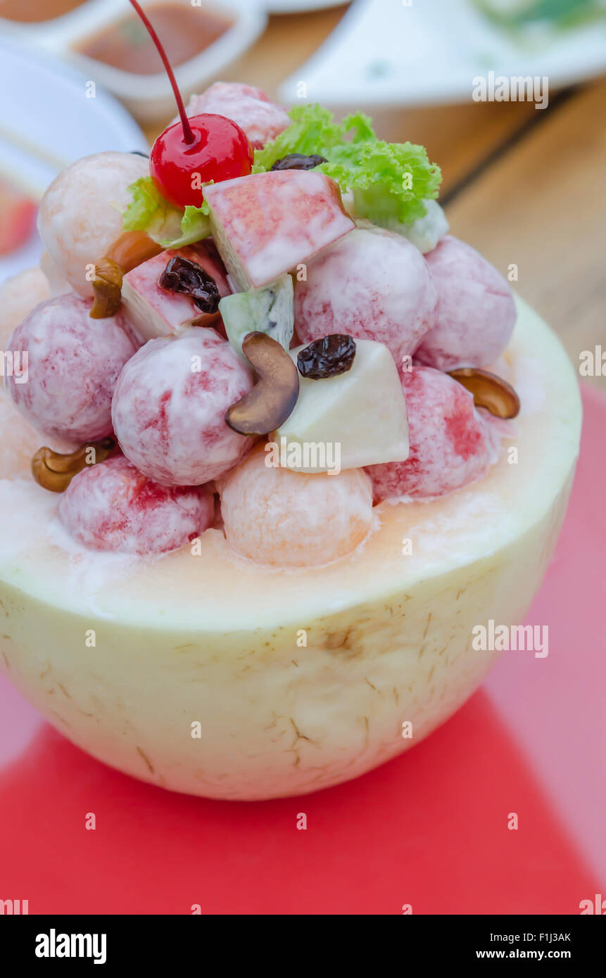 Salade de fruits frais à la crème dans le bol de cantaloup Banque D'Images