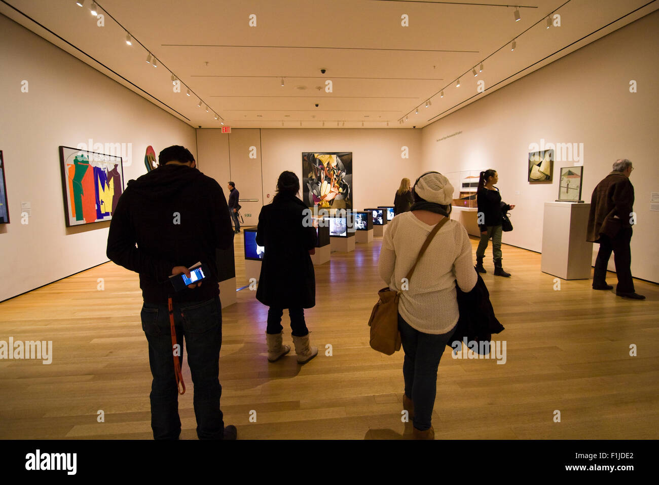 Diverses personnes dans une galerie d'art avec visualisation MoMA une installation de téléviseurs sur le sol et les peintures sur les murs Banque D'Images