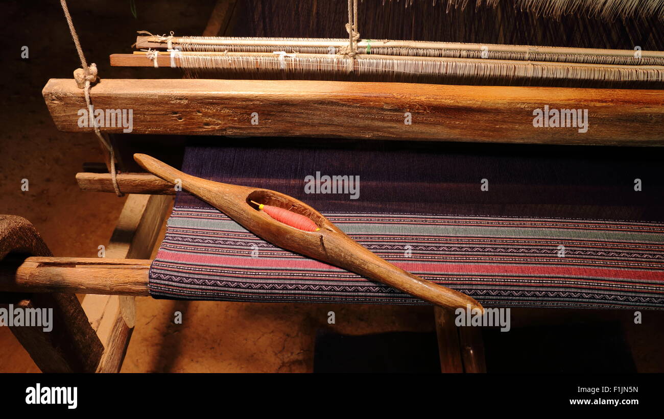 Navette de tissage avec bobbin thread et assis sur un projet en cours sur un métier. Banque D'Images