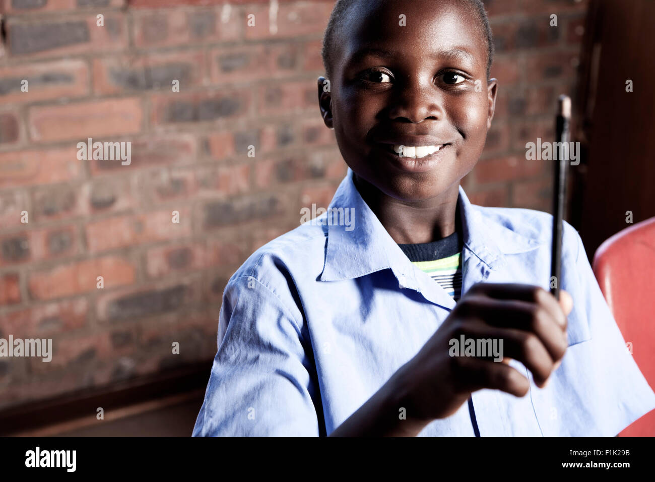 Homme étudiant africain assis à un bureau, smiling at camera Banque D'Images