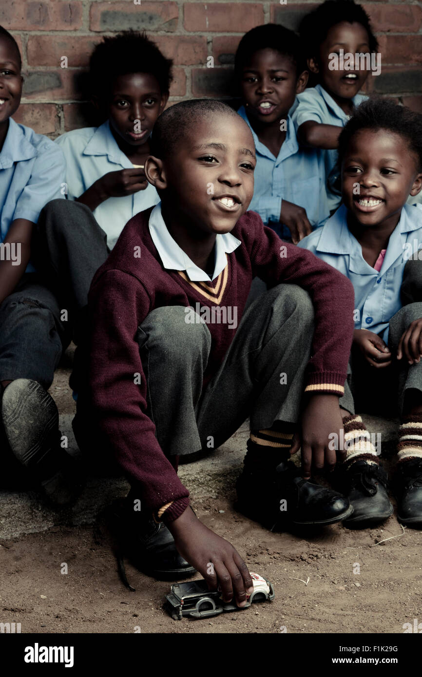 Groupe d'enfants de l'école africaine assis ensemble à l'extérieur Banque D'Images