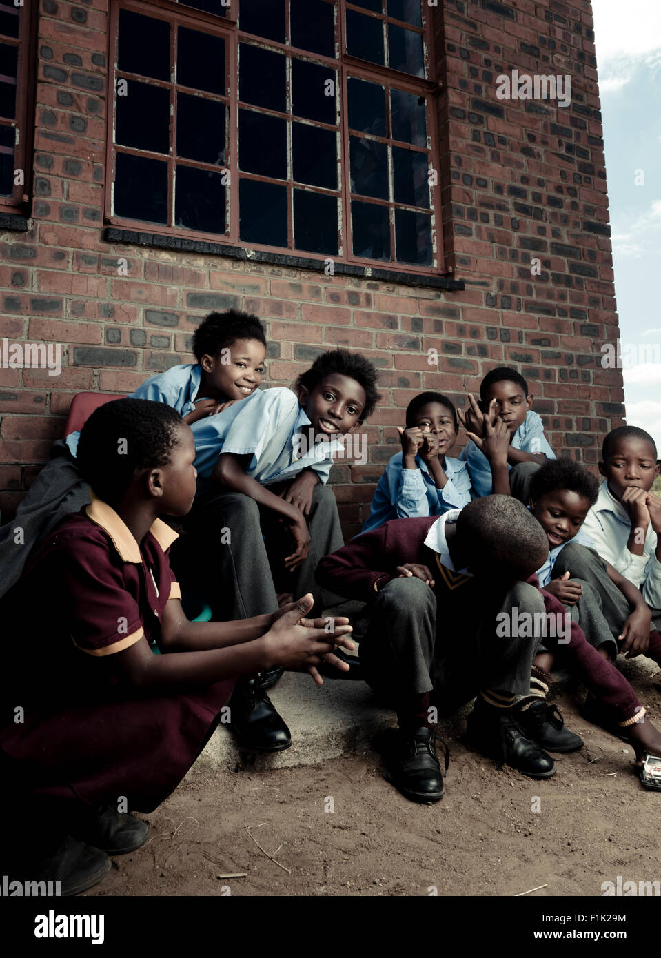 Groupe d'enfants de l'école africaine assis ensemble à l'extérieur Banque D'Images