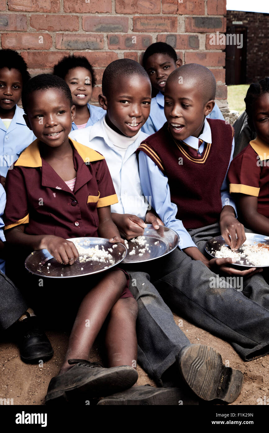 Groupe d'enfants africains de manger ensemble à midi à l'extérieur Banque D'Images