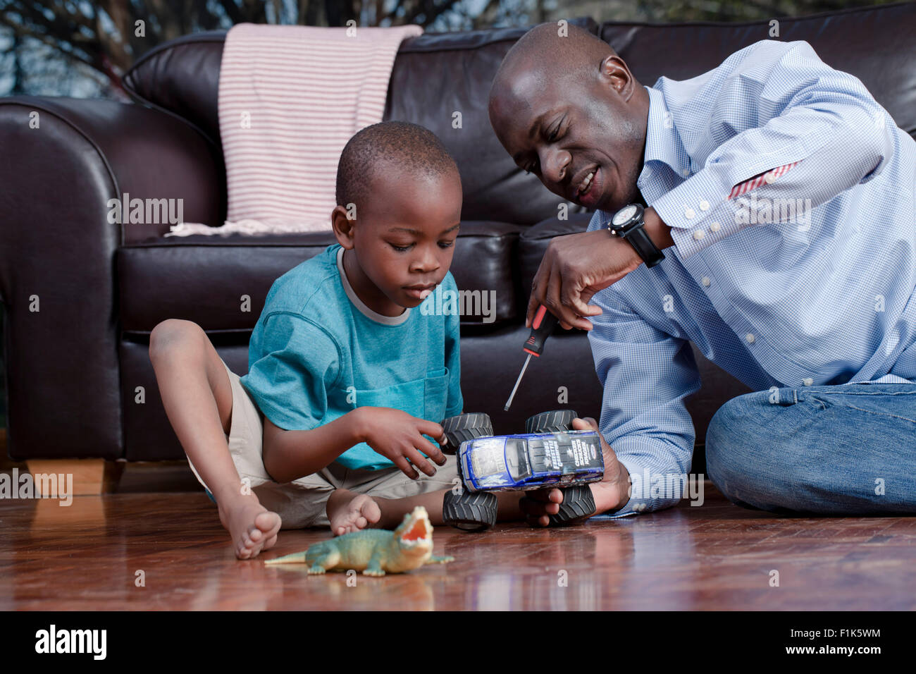 Jeune africain père jouant avec son fils sur le plancher de la salle de séjour Banque D'Images