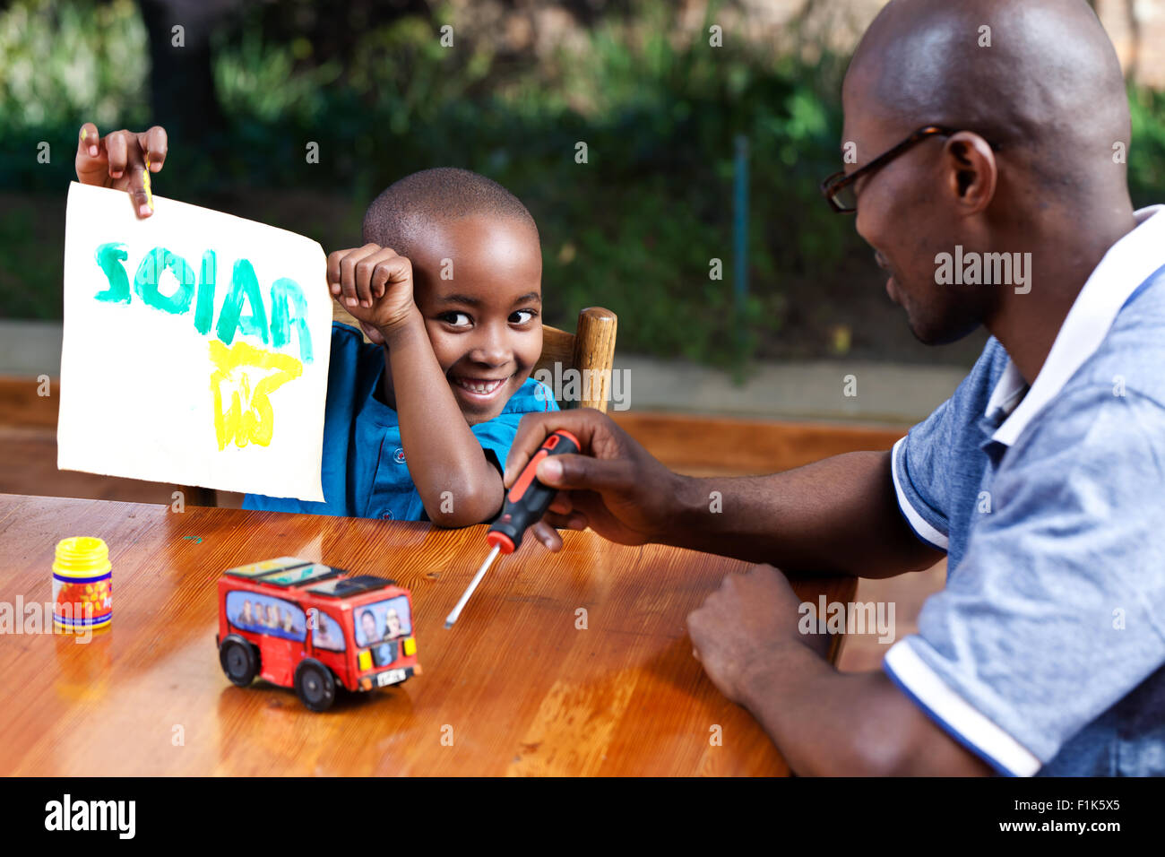 Jeune homme africain jouant à l'intérieur avec son fils Banque D'Images